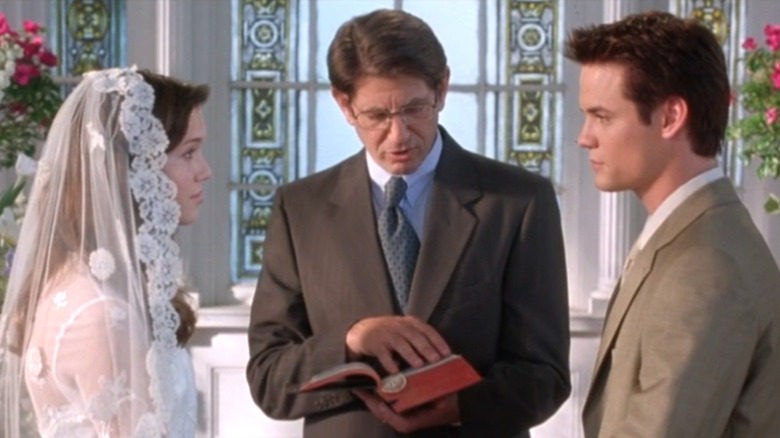 Mandy Moore as Jamie Sullivan stands across from Shane West as Landon Carter while Peter Coyote as Reverend Sullivan reads wedding vows in A Walk to Remember