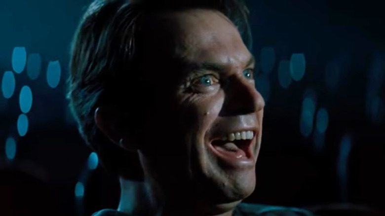 Sam Neill as John Trent laughing wildly in In the Mouth of Madness