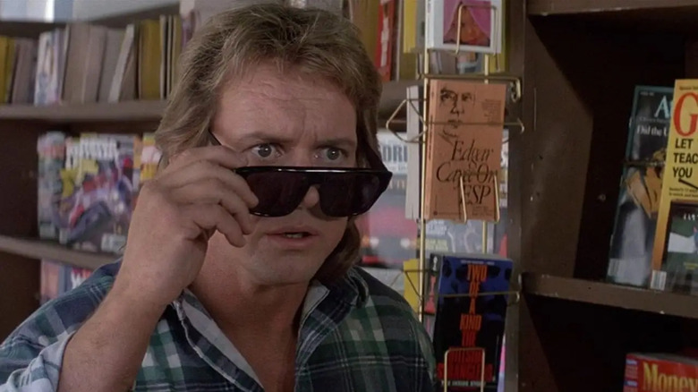 Nada (Roddy Piper) holding his sunglasses down in They Live