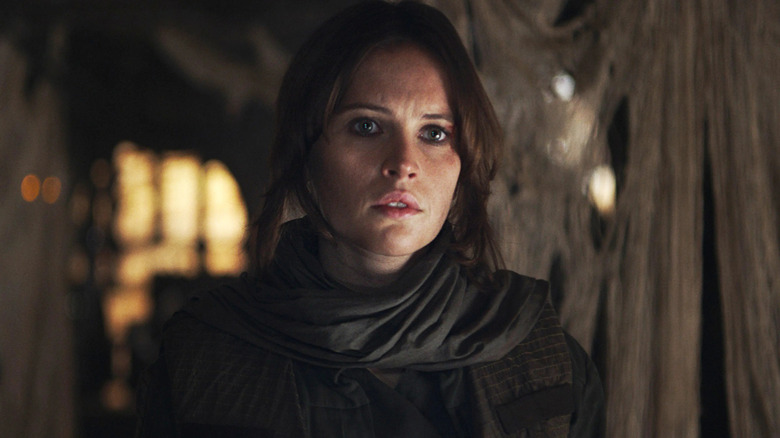 Jyn Erso (Felicity Jones) stares intently in a darkened room in Rogue One: A Star Wars Story