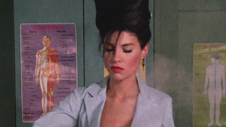 A scientist with an open shirt and beehive in a classroom in The Class of Nuke 'Em High: The Good, the Bad and the Subhumanoid