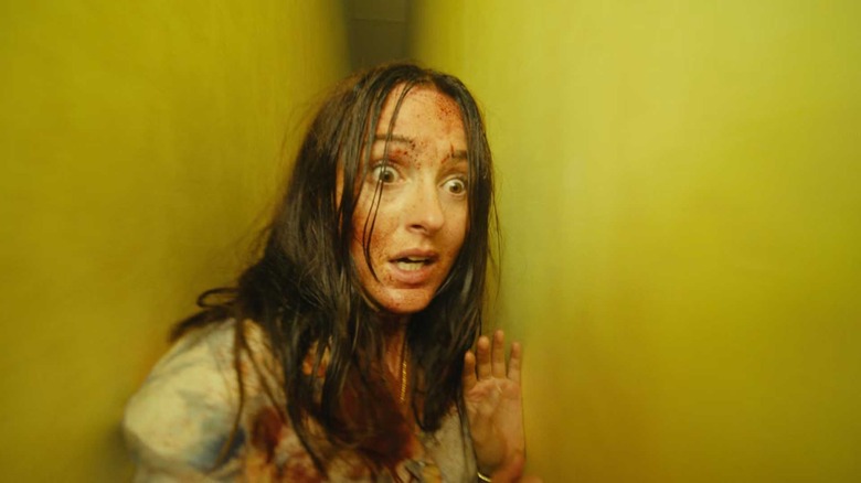 Renate Reinsve as Mary squeezing between two walls in Backrooms
