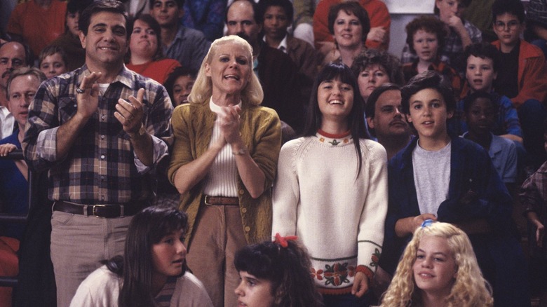 Dan Lauria as Jack Arnold stands on bleachers next to Alley Mills as Norma Arnold, Danica McKellar as Winnie Cooper, and Fred Savage as Kevin Arnold on The Wonder Years