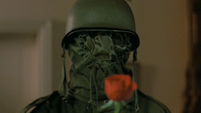 Farley Granger disguised as The Prowler in The Prowler, underneath a camo sheath completely concealing his face and wearing an army helmet.