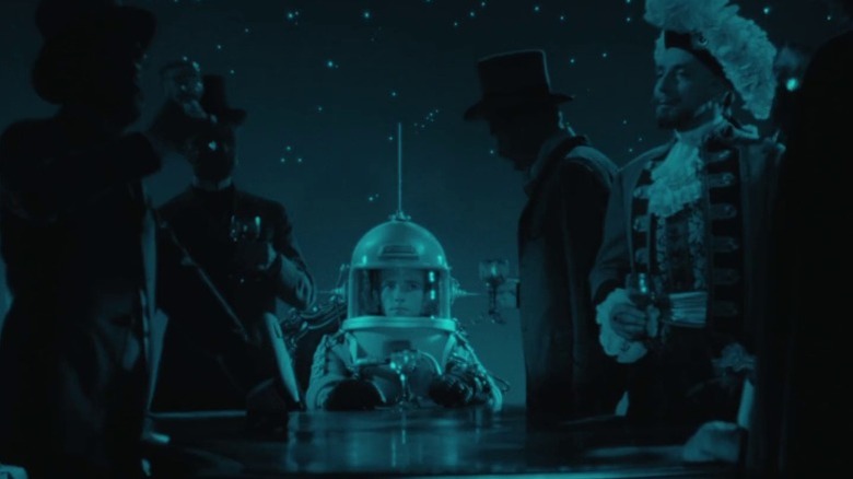 Rudolf Jelínek as Tonik sitting in his spacesuit among Moon residents in 19th-century garments in The Fabulous Baron Munchausen