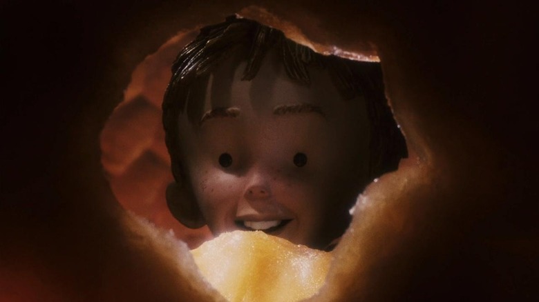 James (Paul Terry) peering through a whole in a peach in James and the Giant Peach