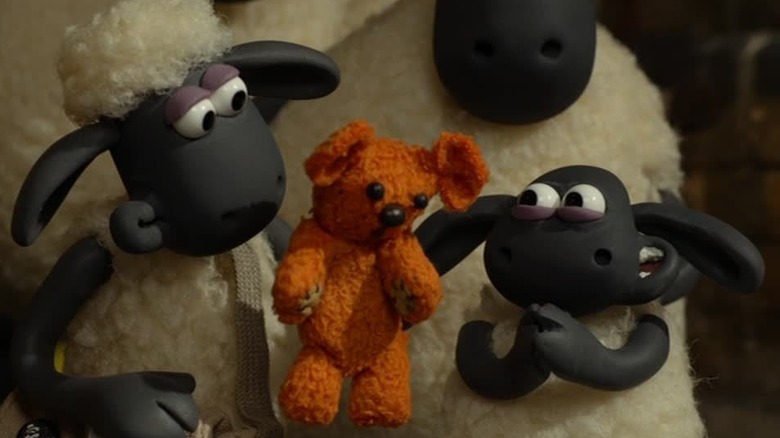 Shaun (Justin Fletcher) holding a teddy bear near Timmy (Fletcher) in Shaun the Sheep Movie