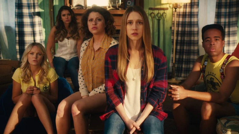 Nancy (Malin Akerman), Vicki (Nina Dobrev), Gertie (Alia Shawkat), Max (Taissa Farmiga), and Blake (Tory N. Thompson) look concerned in a living room in The Final Girls