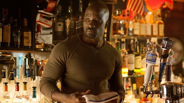 Mike Colter as Luke Cage, standing behind a bar in Luke Cage.