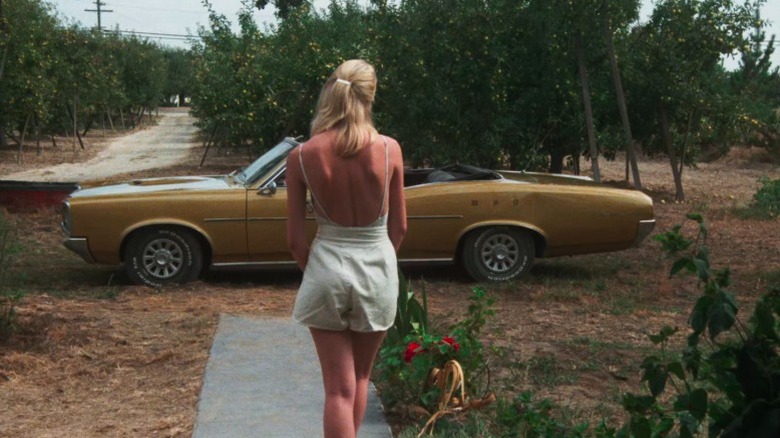 Laura Dern as Connie Wyatt standing before a car parked in her front lawn in Smooth Talk
