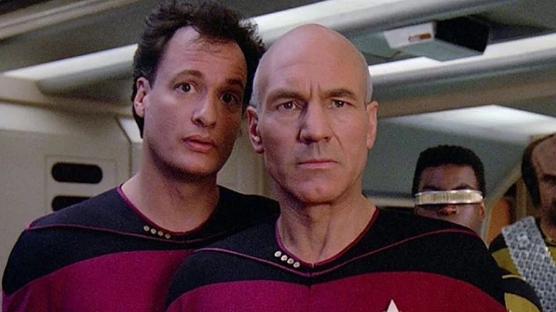 Q (John DeLancie) taunts Picard (Patrick Stewart) as Geordi (Levar Burton) and Worf (Michael Dorn) look on, on Star Trek: the Next Generation