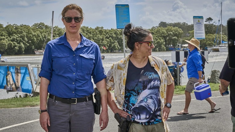 Kate Box as Dulcie Collins and Madeleine Sami as Eddie Redcliffe standing together in Deadloch Season 2