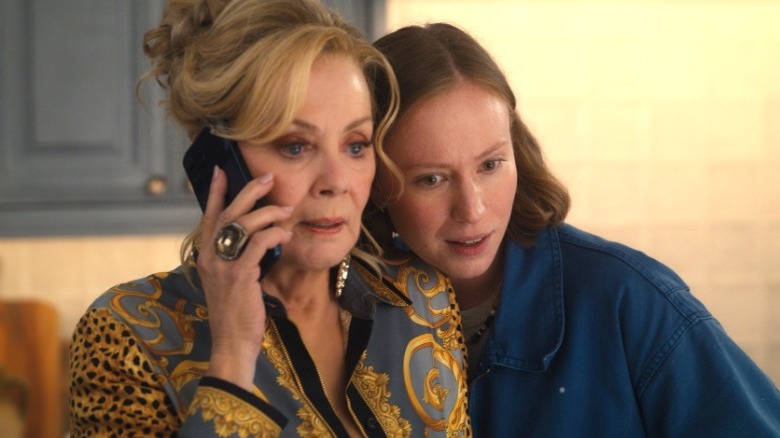 Deborah on the phone with Ava on her shoulder on Hacks