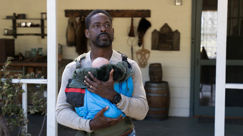 Sterling K. Brown as Xavier Collins holding a baby in Paradise Season 2
