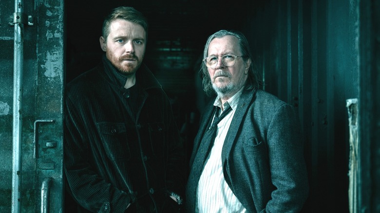 Jack Lowden's River Cartwright stands beside Gary Oldman's Jackson Lamb in a shipping container in Slow Horses