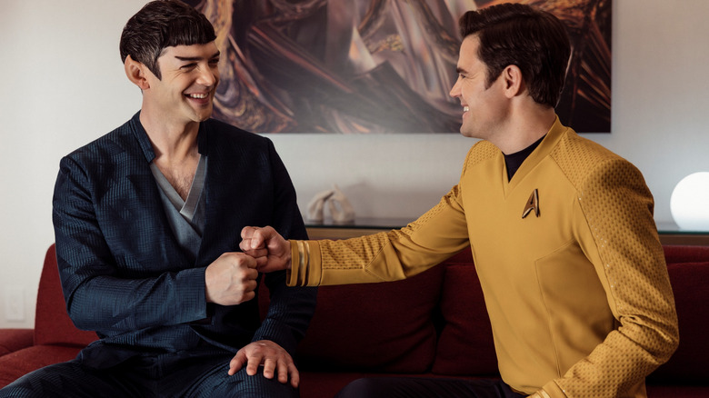 Ethan Peck as Spock and Paul Wesley as James T. Kirk bumping fists on a couch in Star Trek: Strange New Worlds