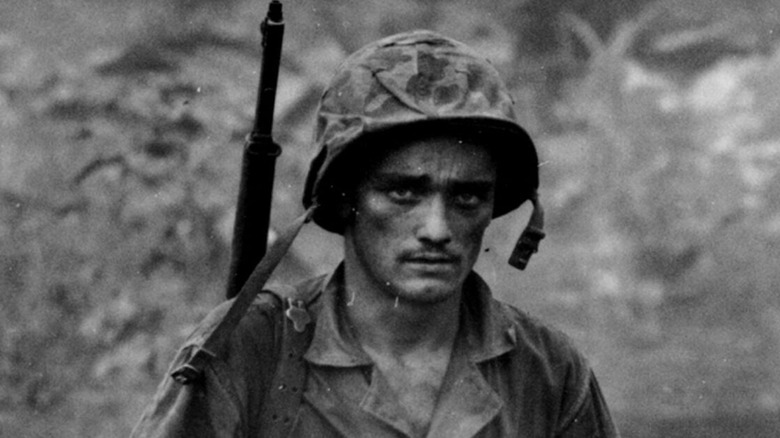 A weary American soldier looks at the camera in The War