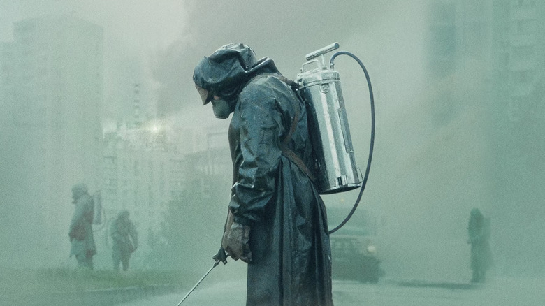 A man in a hazmat suit in a foggy city in Chernobyl