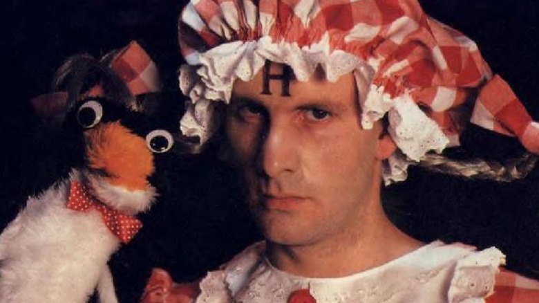 Chris Barrie as Arnold Rimmer, wearing a bonnet and holding a penguin on Red Dwarf
