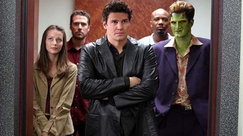 Angel (David Boreanaz) stands with his arms crossed in front of his allies on Angel