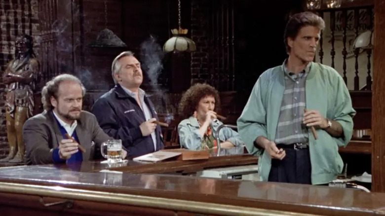 Kelsey Grammer as Frasier Crane, John Ratzenberger as Cliff Clavin, Rhea Perlman as Carla Tortelli, and Ted Danson as Sam Malone smoking cigars at the bar in the series finale of Cheers