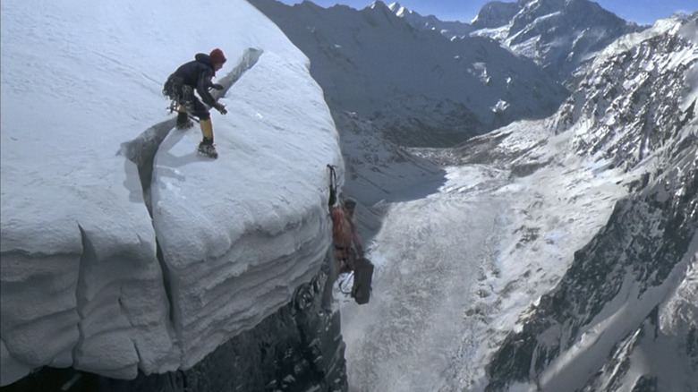 Izabella Scorupco's Monique Aubertine races to the edge of a mountain as a climber dangles from the ledge in Vertical Limit