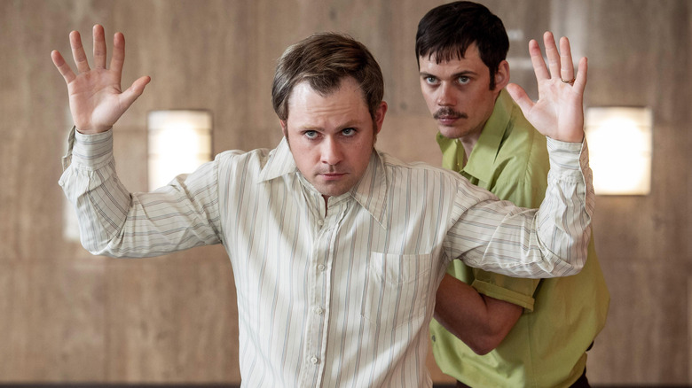 Bill Skarsgård as Tony Kiritsis holding Dacre Montgomery as Richard Hall hostage in his office in Dead Man's Wire