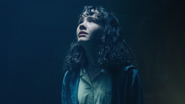 Lilly looks up at the tower of dead children in the sewers in It: Welcome to Derry