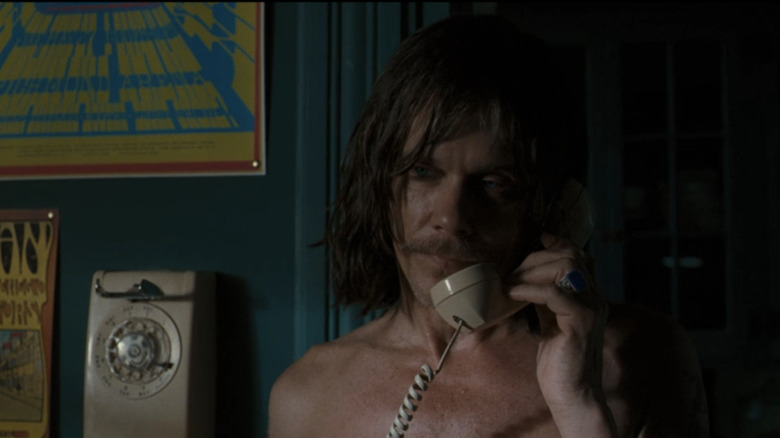 Kevin Bacon's Carroll Caldwell talks on a phone in Jayne Mansfield's Car