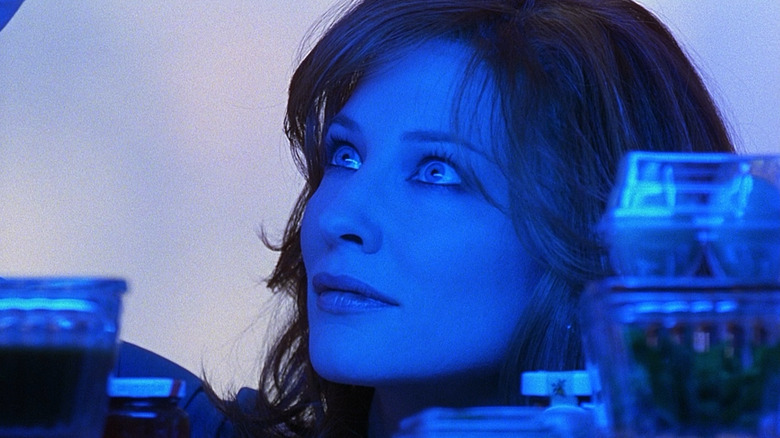 Cate Blanchett as Kate bathed in blue light while looking through a pantry in Bandits