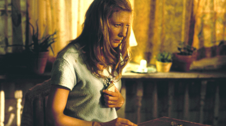 Annie devant une table à cartes, l'air intense dans The Gift