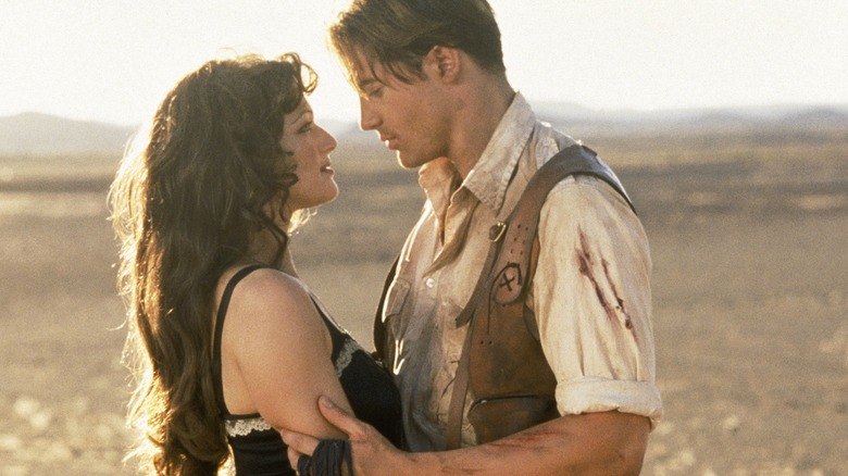 Brendan Fraser as Rick O'Connell and Rachel Weisz as Evelyn Carnahan leaning in for a kiss in the middle of the desert in The Mummy
