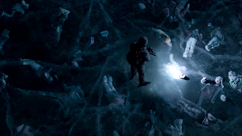 A solder stands on the frozen ice where bodies have been encased below