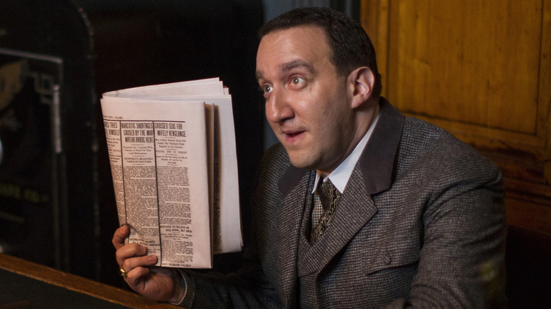 Danny Hoch as Bunky Collier, holding up a newspaper on The Knick