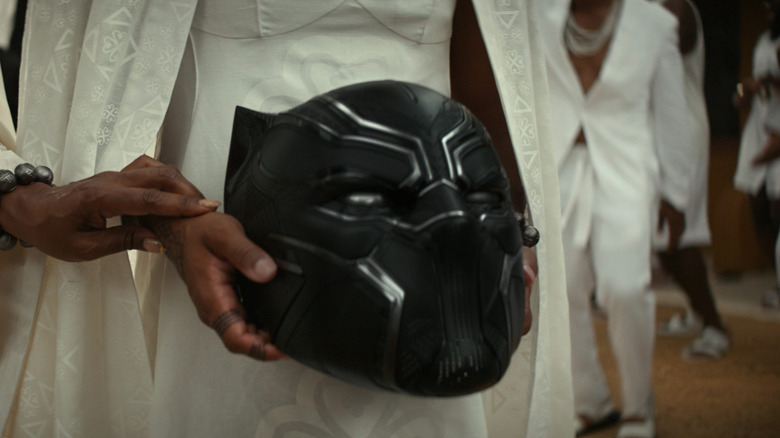 Shuri holding the Black Panther helmet during the funeral in Black Panther: Wakanda Forever