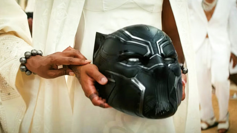 Shuri holding the Black Panther's helmet