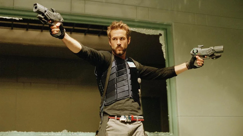 Ryan Reynolds as Hannibal King with sci-fi weapons in front of a broken window in Blade: Trinity