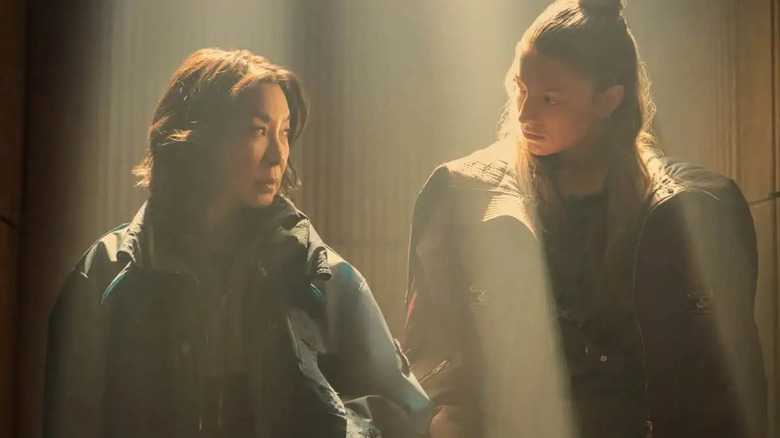Michelle Yeoh as Olwen standing in a brightly-lit room next to Hunter Schafer as Cora in Blade Runner 2099