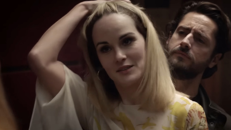 Michelle Dockery's Leticia Raines stands holding her hair in front of Juan Diego Botto's Javier Pereira in Good Behavior