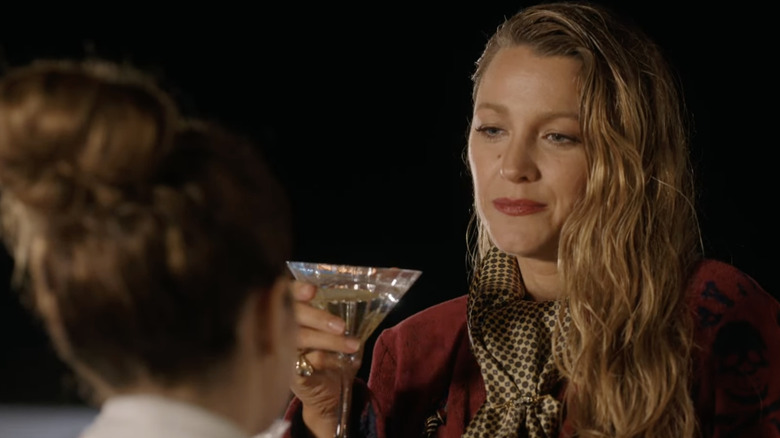 Emily raising a martini in the trailer for Another Simple Favor