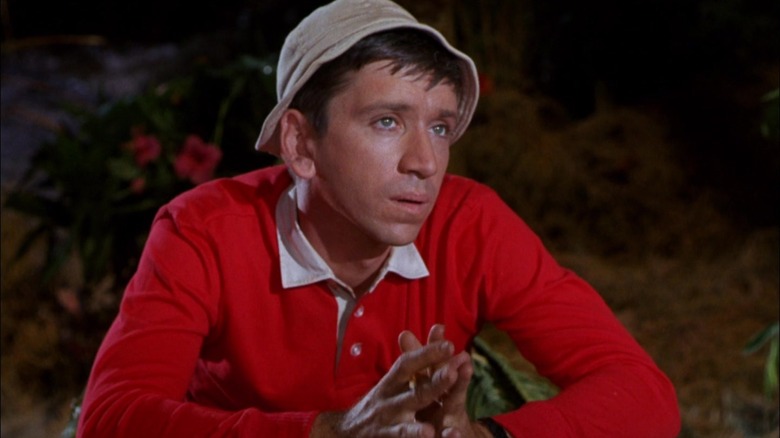 Gilligan sitting at a judge's table looking pensive on Gilligan's Island.