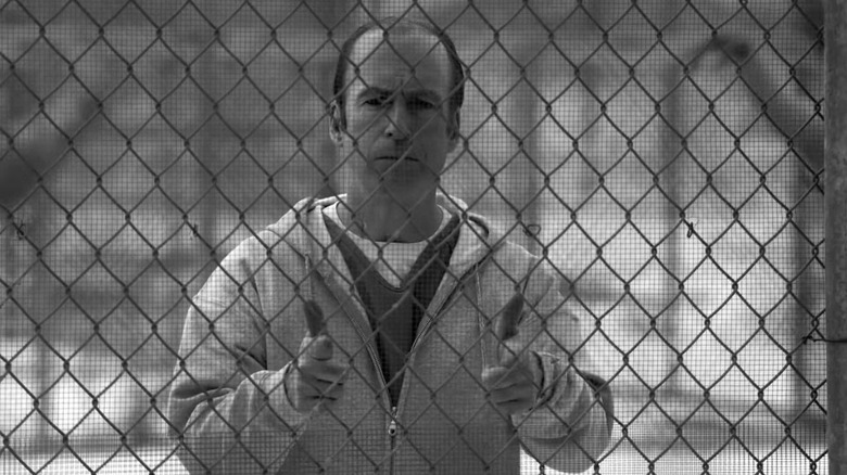 Jimmy McGhel refers to the finger defender behind the prison chain fence while wearing his clothes in the prison in the end in black and white "Best Saul's invitation"