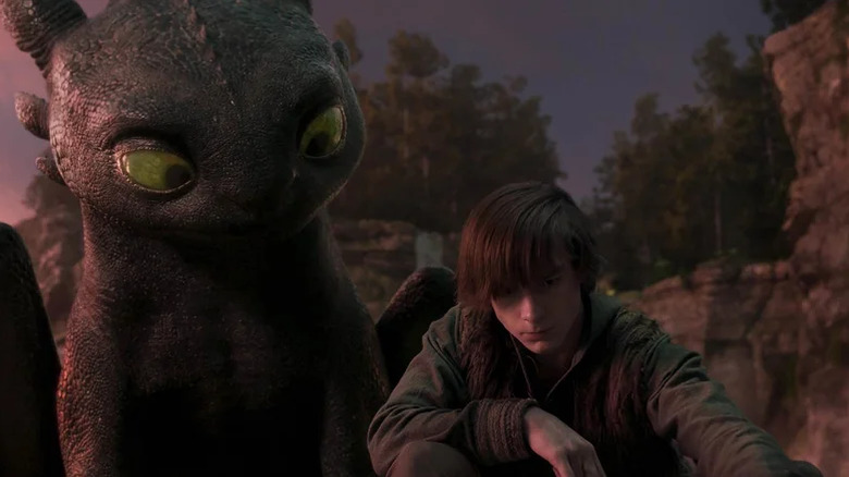 Toothless watches over Hiccup's shoulder with curiosity in How to Train Your Dragon