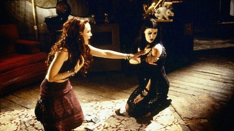 Erica and Kim realizing the X carved into her arm while kneeling on the ground in Book of Shadows: Blair Witch 2