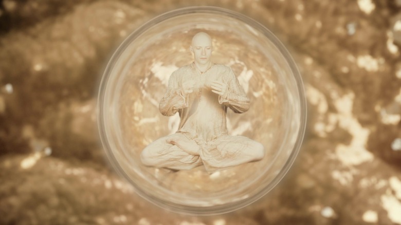 Tom the Space Traveler inside a buddle surrounded by gold in The Fountain