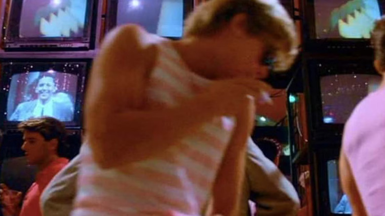 Brad Pitt as an extra in front of several TV screens in Less Than Zero