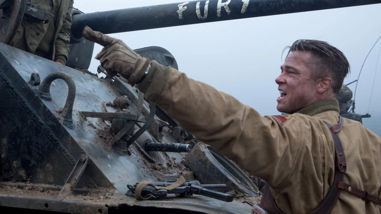 Norman sits on top of a military tank labeled Fury while Don angrily points his leather-gloved hands to the left in Fury