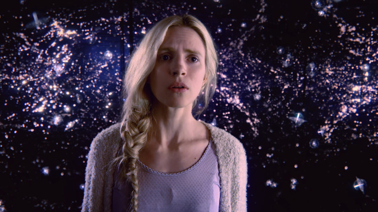 Brit Marling as Prairie Johnson stands against an abstract background in The OA