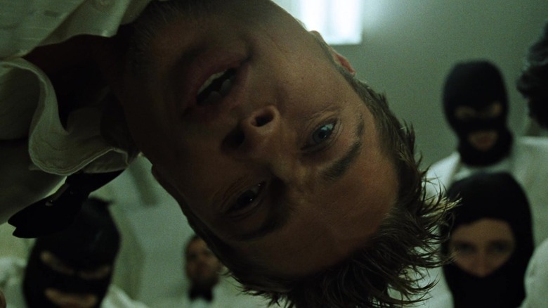 Tyler Durden and some guys in maks crowded around the camera in Fight Club
