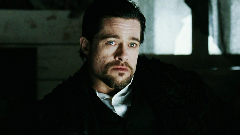 Brad Pitt's Jesse James sits in darkness in The Assassination of Jesse James by the Coward Robert Ford